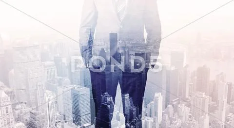 Business man standing on roof with city in the background Stock Photos