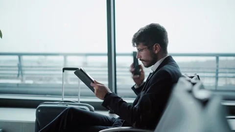 Business man with a tablet making a call on his smartphone. Stock Footage 221120607