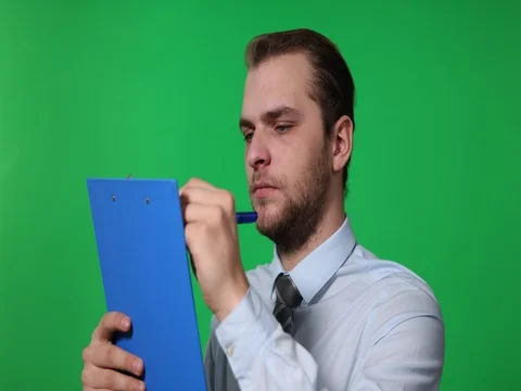 Business Man Take Notes Writing on Clipboard Looking Up Green Screen Background Stock Footage 77007703