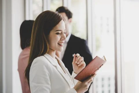 Business man is taking note in front of two friend office worker in the backg Stock Photos