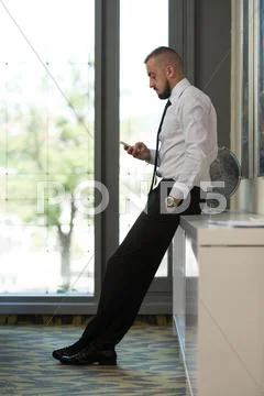 Business man texting on cellphone in modern office Stock Photos