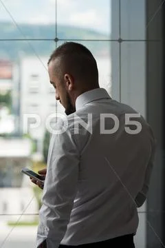 Business man texting on cellphone in modern office Stock Photos