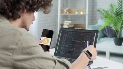 Business man trader using mobile phone app and laptop analytics. Stock Footage 165339149