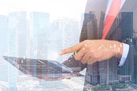 Business man Trading concept using the tablet with financial graph on citys.. Stock Photos