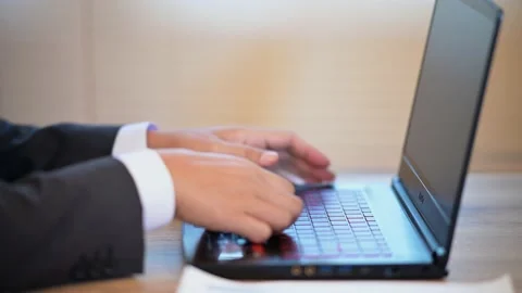 The business man is typing data on a laptop on the desk Stock Footage 137516271