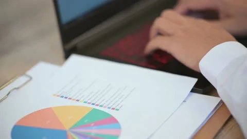 The business man is typing data on a laptop on the desk Stock Footage 137516310
