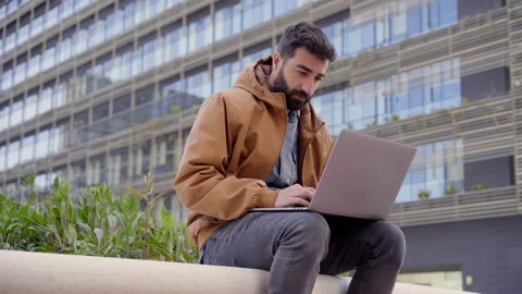 Business man typing on laptop computer outdoors. Casual dressed man working w Stock Footage 153251250