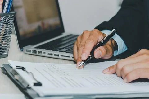 Business Man using computer laptop and pen paperwork document a desk. Busin.. Stock Photos