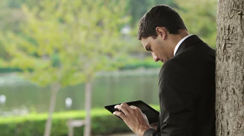 Business man using digital tablet at park Stockbeeldmateriaal 32360304