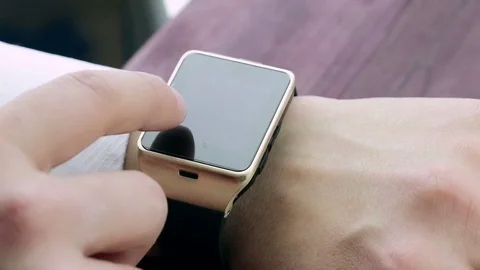 Business man using his smartwatch app near wood table background, new technology Video stock 80046232