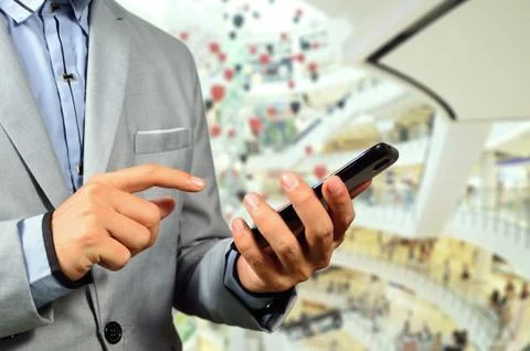 Business Man using Mobile Cell Phone in The Modern office building. Stock Photos