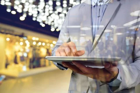 Business Man using Mobile Digital Tablet in the Modern Shopping Mall. Selecti Stock Photos