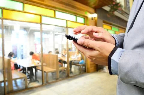 Business man using mobile smart phone in Restaurant or Food Court Plaza Stock Photos