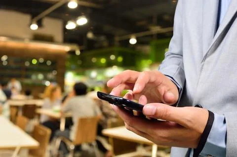 Business man using mobile smart phone in Restaurant or Food Court Plaza Stock Photos