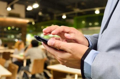 Business man using mobile smart phone in Restaurant or Food Court Plaza Stock Photos