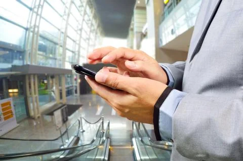 Business Man Using Mobile while going down Escalator Stock Photos