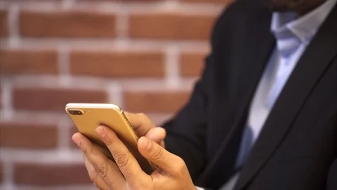 Business man using smart phone - Close up -  Brick wall background Stock Footage 72641119