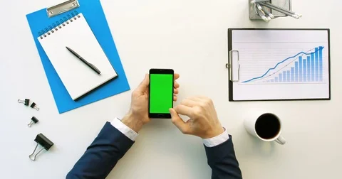 Business man using smart phone with green screen, scrolling pages, tapping on Stock Footage 74689114