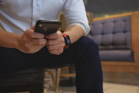 Business man using smartphone application to communicate with colleague while Stock Photos