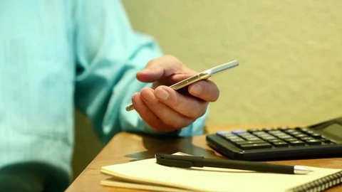 Business Man Using Smartphone Typing Text. On The Table Calculator Video stock 72988309