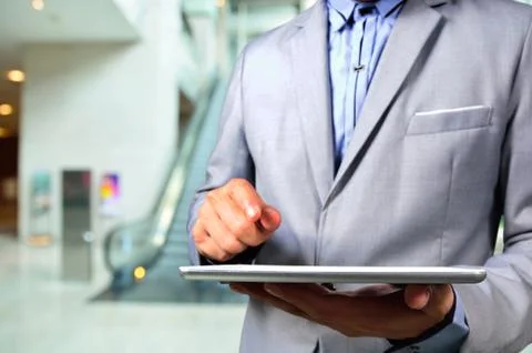 Business Man using Tablet PC in Office building escalator Stock Photos