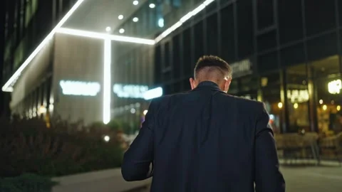 Business man walking outside at night. Male in official near business center Stock Footage 303672974
