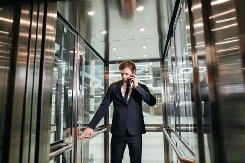 Business man walking while talking on mobile phone on his way to work Fotos de archivo
