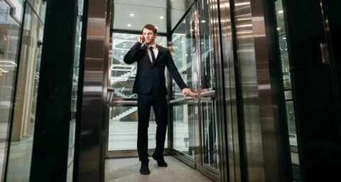 Business man walking while talking on mobile phone on his way to work Fotos de archivo