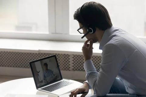 Business man in wireless headset using laptop Stock Photos