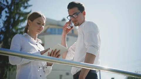 Business man woman tablet computer standing street talking phone using laptop Stock Footage