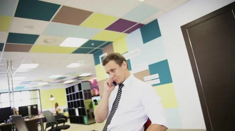 Business man working at laptop computer and talking on mobile phone Stock Footage 66300472