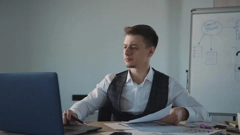 Business man working on laptop computer and writing on a paper with pen Stock Footage 119460599
