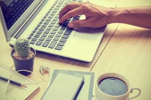 Business man is working by using a laptop computer on wooden desk Stock Photos
