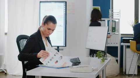 Business manager checking data charts with files and computer Stock Photos