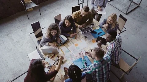 Business meeting at loft shared space. Multiethnic team talking, woman manager Stock Footage 75433207