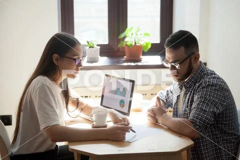 Business meeting: two millennial coworkers solving working quest Stock Photos