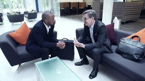 Business men having a discussion in office lobby Stock Footage 59397259