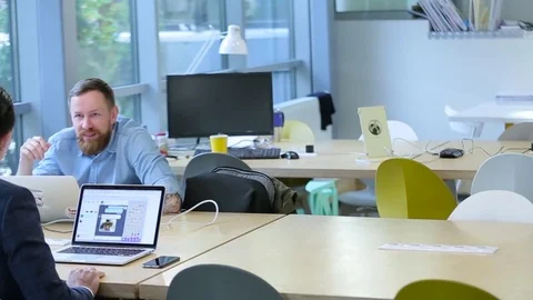 Business men talking in an office with laptops Stock Footage 70585073