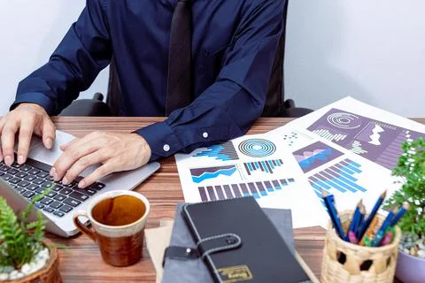 Business men use notebook computers to work at their desks Stock Photos