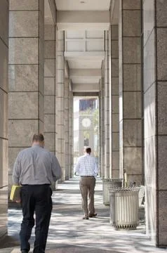 Business Men walking outside of building on sunny day Stock Photos