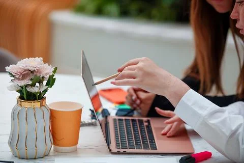Business mentor explaining project on laptop to colleague at marble desk Stock Photos