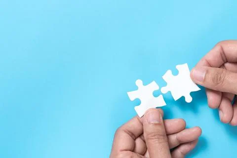 Business merging concept using white jigsaw puzzle Stock Photos