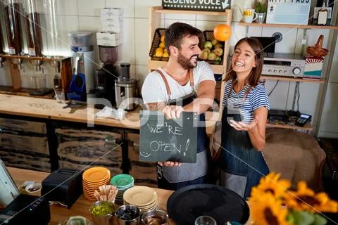 Business owner holding Open Sign. couple opening their store. Stock Photos