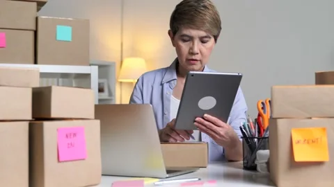 Business owner using tablet checking address and delivery detail before shipping Stock Footage 160883682