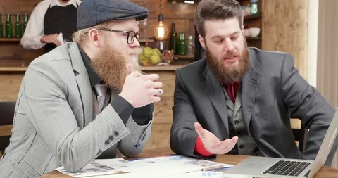 Business partners analyzing and comparing data from the computer Stock Footage 104971927