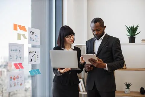Business partners developing plan in office using computer Stock Photos