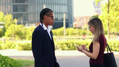 Business partners discussing and using smartphones in the financial district Stock Footage 317014362