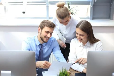 Business partners discussing documents and ideas at meeting. Stock Photos