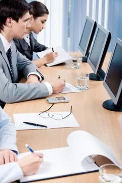Business partners making notes while sitting in front of computers 库存照片