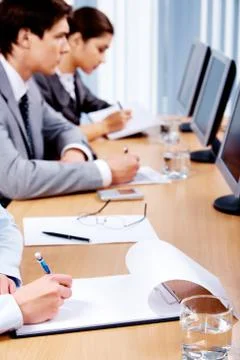 Business partners making notes while sitting in front of computers 库存照片
